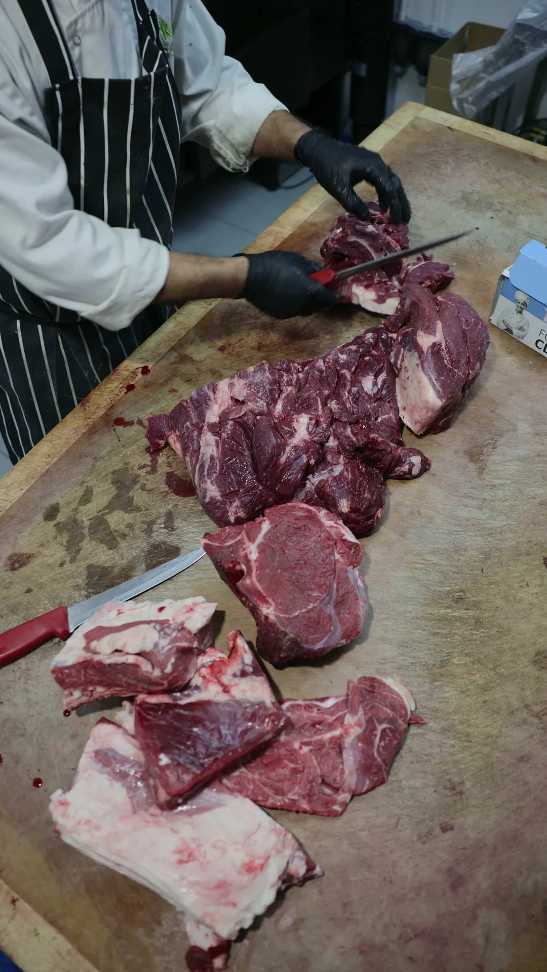 Our butcher cutting fresh halal meat to order on the block